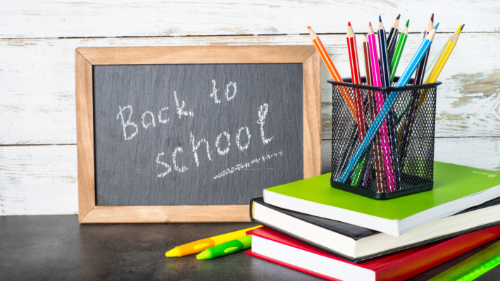 Ardoise « Back to school » et fournitures de bureau illustrant la rentrée du système d'information.